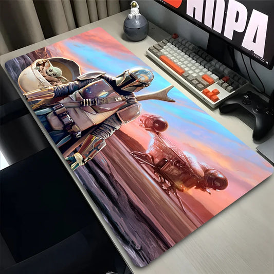 Desk setup with a large mouse pad featuring an astronaut design, keyboard, and monitor.
